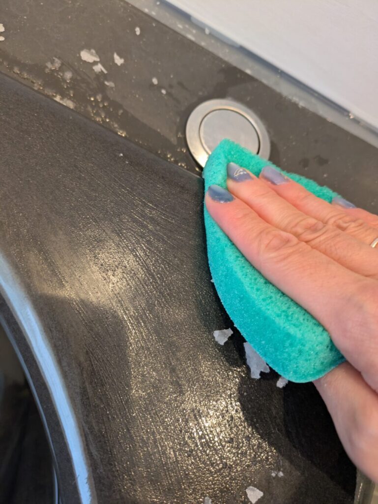 スコッチブライトで浴槽の水垢をこすっている